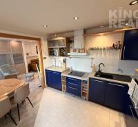 A kitchen in a 3-room apartment with a blue kitchen unit and a dining table.