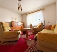 Living room in a family house with a sofa set, carpet, and wooden furniture.
