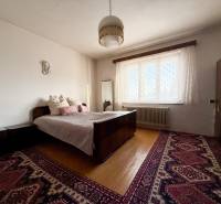 Bedroom with carpet, bed, and wood-patterned flooring in a family house.