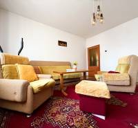 Living room in a family house with comfortable seating on a red oriental carpet.