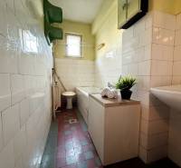 A bathroom in a family house with a sink, bathtub, toilet, and tiled floor.