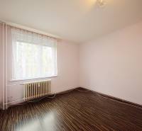 A room in a 3-room apartment with a wooden decor floor and a large window.