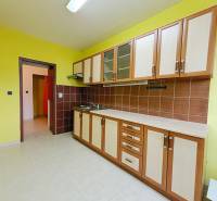 A kitchen unit with tiles and yellow walls in a 3-room apartment.
