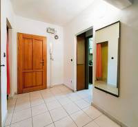 A bright hallway in a 3-room apartment with tiles and a large mirror.
