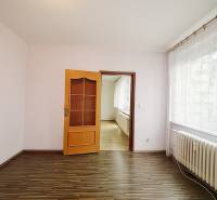 A room in a 3-room apartment with a wooden decor floor and a large window.