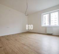 Empty room with wooden floor, white walls, and a window.