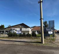 Commercial premises in Dolné Chlebany with parked cars and fencing.