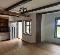 Interior of commercial spaces with a wooden beam ceiling and a floor with a wooden decor.