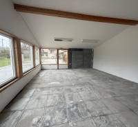 Open space in commercial premises with large windows and concrete floor.