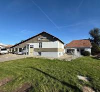 Commercial premises in Dolné Chlebany with a lawn and parking for cars.