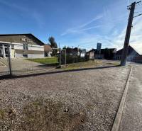 Commercial premises in Dolné Chlebany, fencing, paved area, and asphalt road.