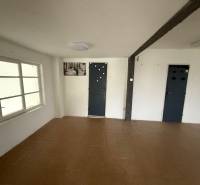 Commercial space with wood-patterned flooring, white walls, and a window.