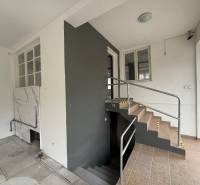 Interior of commercial premises with tiles and stairs, railing leading to a lower floor.