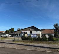 Commercial premises in Dolné Chleby with parking in front of the building and signage for rent.