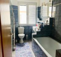 Bathroom in a 2-room apartment with a bathtub, blue tiles, and a toilet.