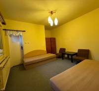 Living room in a family house with sofas, a table, and yellow walls.