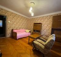 Living room in a family house, floral wallpaper, wooden decor flooring, wooden furniture.