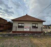 A family house in the center of Veľké Lovce with a brick roof and fencing.