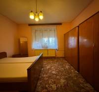 Bedroom in a family house with a wardrobe, bed, and carpet.