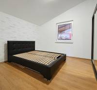 Bedroom in a family house, with a bed and a wooden decor floor.
