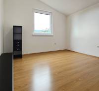 A room in a family house with a wooden decor floor and a storage shelf.