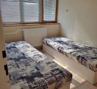 A room with two beds and blinds in a studio apartment, decor with English motifs.