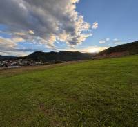 Sunset over the green lands in Margecany, surrounded by hills and the sky.