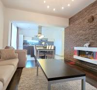 Interior of a 3-room apartment with a fireplace, wood-patterned flooring, and a comfortable sofa set.