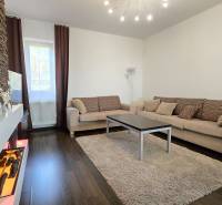 Living room in a 3-room apartment with a stone wall and a wooden decor floor.