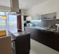 Stylish kitchen in a 3-room apartment with a dining table, view, and modern appliances.
