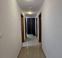 A hallway in a 3-room apartment with light walls and tiles.