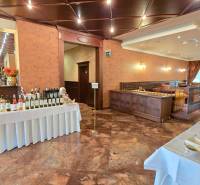 A restaurant with wines, a table with food, wooden decor, and well-lit seating.