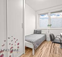Children's room with a bed, wardrobe, and desk. Floor with wooden decor.