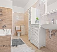 A bathroom with a bathtub and tiles in a 3-room apartment.