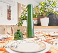Dining table in a 3-room apartment with a floral tablecloth and decorations.