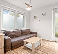 Living room in a 3-room apartment with a brown sofa and a wooden decor floor.