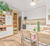 A kitchen in a 3-room apartment with a wooden decor floor and floral decorations.