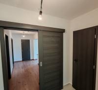 Interior of a 3-room apartment with a wooden decor floor and sliding doors.