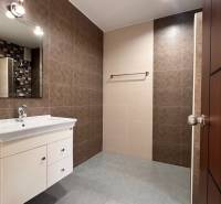 A bathroom in a villa with a sink, mirror, and tile cladding.