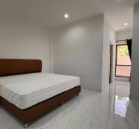Interior of a villa with a bed and shiny ceramic tiles.