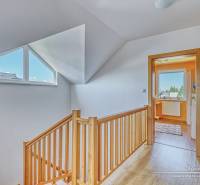 A family house with a wooden decor floor, staircase, and a bright hallway.