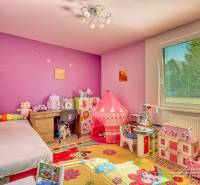 Children's room in a family house with toys and furniture, floor with wooden decor.