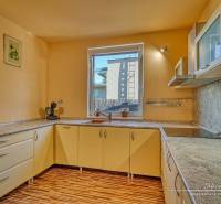 A kitchen in a family house with a window and a floor with a wooden decor.