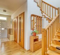 A staircase with a wooden railing in a family house, a floor with a wooden decor, storage spaces.