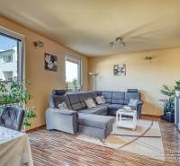 A living room in a family house with a comfortable sofa corner and a wooden decor floor.