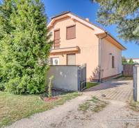 A family house on Cífer Street in Cífer surrounded by trees and green grass.