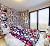 A room with patterned wallpaper, a bed, and a large plush bear in a 4-room apartment.