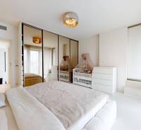 A bright bedroom with a baby crib and a built-in wardrobe in a 4-room apartment.