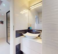 A bathroom with a sink and glossy tiles in a 4-room apartment.