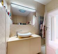 A bathroom with light tiles, a sink on a cabinet, and a ladder radiator in a 4-room apartment.